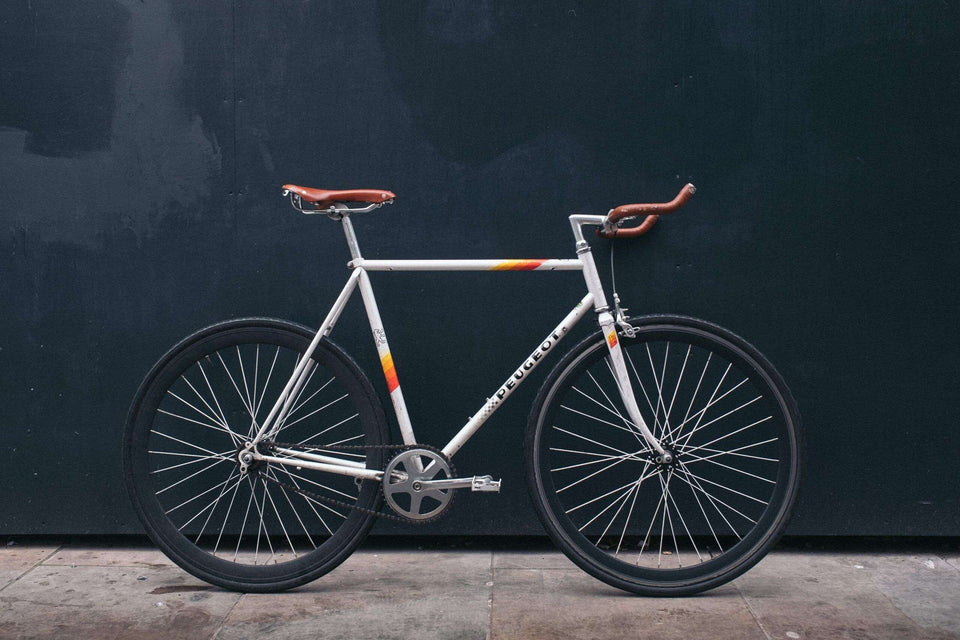 Cykel parkerad mot en mörk vägg